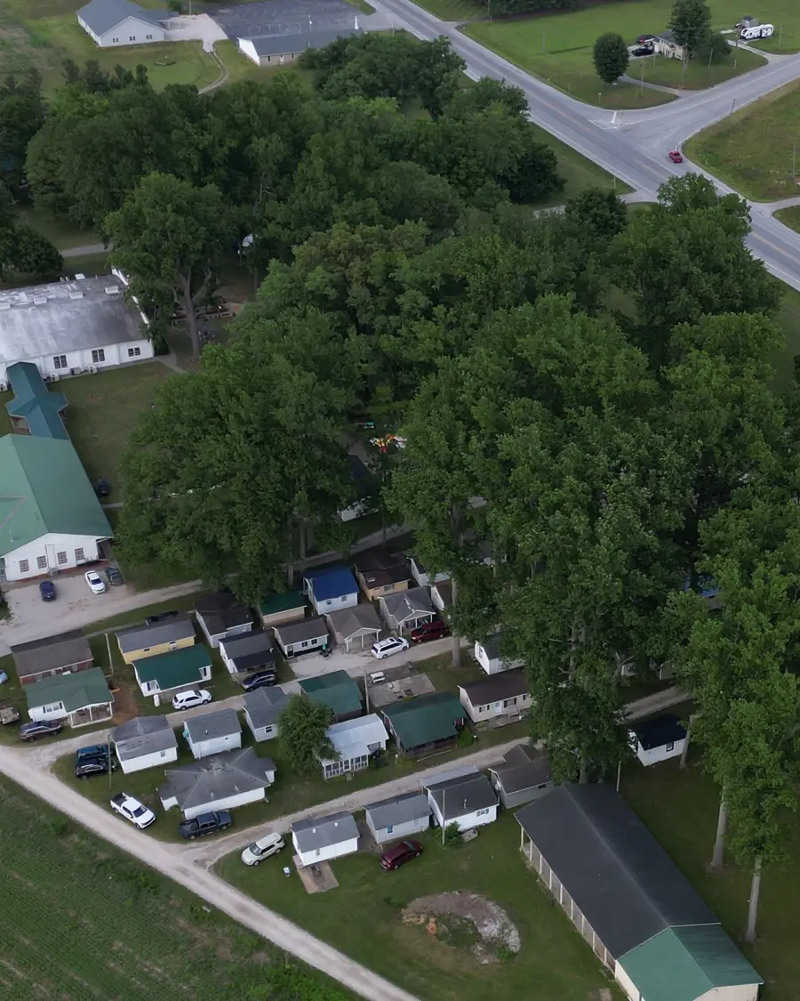 The campground from the air — the long lodging building, the cabins along the loop road, and the fields and highway beyond