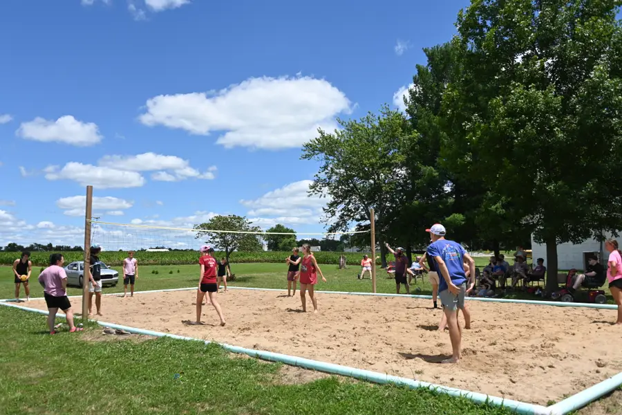 The sand volleyball court in use on a clear afternoon